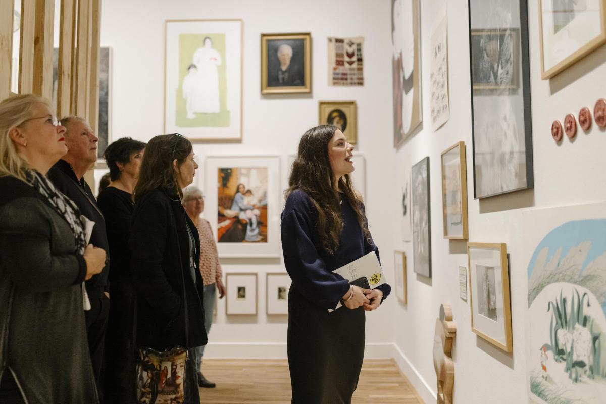 Vrouw geeft rondleiding in museumzaal